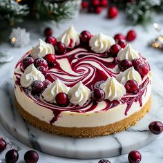 a cheesecake topped with cranberries and whipped cream on a marble platter