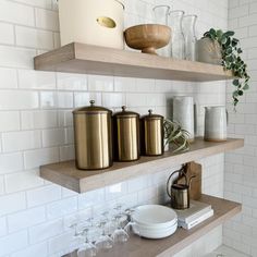 some shelves with pots and glasses on them in a white tiled room, along with other items