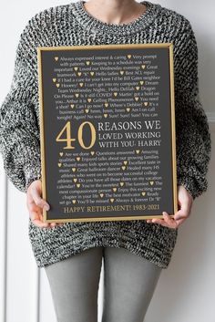 a woman holding up a sign with the words 40 years in gold and black on it