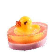 a yellow rubber ducky floating on top of a pink soap dish with water droplets around it