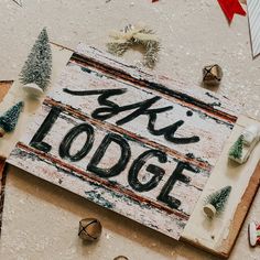 a wooden sign that says ski lodge surrounded by christmas decorations and other holiday decor items