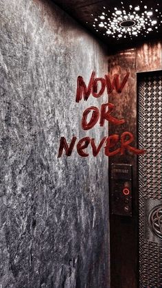 the words move or never are spray painted on a wall in front of an elevator