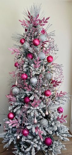 a silver and pink christmas tree with ornaments