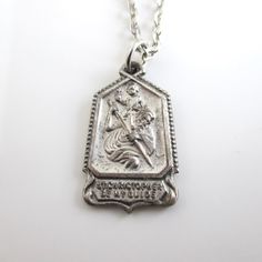 A vintage silver tone St. Christopher Be My Guide pendant with "I am Catholic..." on the back side.  I added a simple silver tone chain and you can choose 18" or 20" length.  Medal is 1" in length.  Some vintage wear (I haven't polished or done anything to the pendant). Please check out my store with similar things added almost daily. Remember, shipping for additional items is always free. Classic Silver Necklace With Vintage Charm, Silver Classic Necklace With Vintage Charm, Silver Necklace With Vintage Charm, Nickel Free Silver Necklace For Memorial, Vintage Nickel Free Necklaces For Commemoration, Vintage Silver Necklaces With Vintage Charm, Personalized Vintage Silver Jewelry, Vintage Personalized Sterling Silver Necklace, Vintage Silver Necklace With Vintage Charm