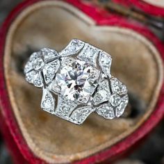 an antique diamond ring sits in a heart - shaped box