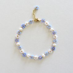 Blue flower bracelet with pearls Daisy flower bracelet for women  Freshwater pearl bracelet Gold Filled Jewelry Dainty Handmade Bracelet 24k gold plated brass chain and clasp. To determine your exact wrist/ankle size, get a tape measure! The bracelet is made of light blue and white Czech beads size 10/0 (about 2mm diameter), freshwater pearls measuring about 4mm and a 24k gold plated clasp and extension chain. Cute and delicate daisy bracelet with pearls will add a light touch to your casual and holiday outfits! Lobster clasp and extender for length adjustment and easy removal. Bracelet Pearl Ideas, Pearl Beads Bracelet, Self Made Bracelets, Flower Bead Bracelet Tutorial, Homemade Jewelry Bracelets, Pearl Bracelet Ideas, Blue And Gold Jewelry, Cute Beaded Bracelets, Flower Pearl Bracelet