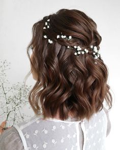 the back of a woman's head, with flowers in her hair and baby's breath