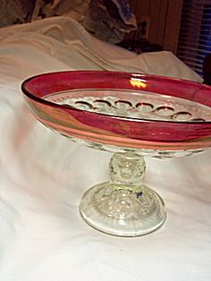 a glass bowl sitting on top of a bed