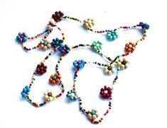 "Add colorful floral fun to your outfits with this charming necklace featuring hand-beaded flowers all along its generous 24\" length! Vibrant multicolored beads form little flowers and add delicate, yet eye-grabbing style as they dangle! And perhaps buy a couple chains at a discount to double the floral loveliness! And consider a coordinating ankle bracelet, pictured above to complete your set! Beaded Flower Necklace (elasticized cord), 24\" long, flowers 1/2\" diameter MANY ARTFUL ITEMS ARE AV Multicolor Beaded Necklace With Flower Charm For Summer, Beaded Flower Necklace For Summer Gifts, Summer Flower Beaded Necklaces, Multicolor Round Beads Flower Necklace For Summer, Multicolor Flower Necklace For Summer Beach, Summer Flower Necklace With Tiny Beads, Summer Flower Necklace With Tiny Round Beads, Bohemian Multicolor Flower Necklace For Summer, Spring Multicolor Beaded Flower Necklace