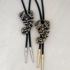 "Original scorpion design was hand carved, then cast in the Heliotrope studio in Tucson, AZ. Cast in solid brass (gold tone), or white bronze (silver tone). Cord is machine braided black or tan leather. At checkout, please choose the desired cord length: 36\"----- Recommended for people under 6' tall. 42\"----- Recommended for people 6' tall or taller. Scorpion measures 2.4\" tall x 1.5\" wide. PLEASE NOTE: final two photos (AND the video) show a comparison between the LARGE SCORPION BOLO TIE (t Vintage Black Jewelry For Western-themed Events, Western Engraved Jewelry For Rodeo, Artisan Hand-tooled Jewelry For Rodeo, Western Style Engraved Jewelry For Rodeo, Western Black Jewelry For Rodeo, Black Western Style Jewelry For Rodeo, Black Engraved Western Jewelry, Black Concho Jewelry For Western-themed Events, Black Engraved Jewelry For Festivals