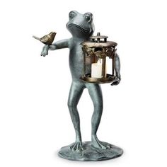 a frog figurine holding a lantern and a bird