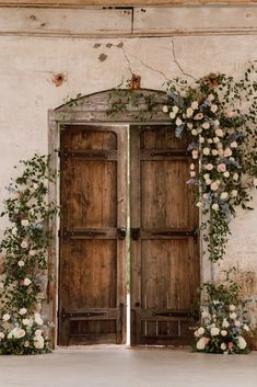 an open wooden door with flowers on it