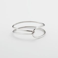 two silver rings on top of each other, one with an open loop in the middle