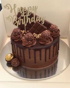 a birthday cake with chocolate frosting and decorations