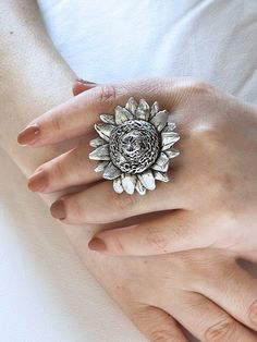 Dress your fingers with the splendor of nature with our Handmade Sunflower Big Ring. Meticulously crafted, this piece of boho-chic jewelry is a testament to individual style and artisanal quality. The ring features a radiant sunflower design, symbolizing happiness and warmth, making it an eye-catching centerpiece for any ensemble. Forged from high-quality silver plating, this chunky ring is not only gorgeous but durable and made to last. Adjustability is at the heart of this design, ensuring a c Handmade Bohemian Sterling Silver Flower Ring, Nickel Free Bohemian Ring, Nickel-free Bohemian Ring Jewelry, Nickel-free Bohemian Style Ring, Nickel-free Bohemian Ring, Bohemian Sunflower Jewelry For Gift, Bohemian Sunflower Jewelry As Gift, Bohemian Sunflower Design Jewelry As Gift, Bohemian Silver Flower Ring Nickel Free