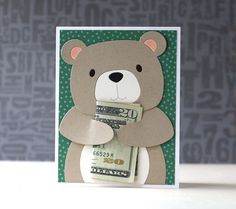 a card with a teddy bear holding money