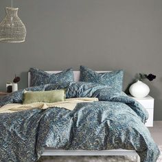 a bed with blue and green comforters in a bedroom