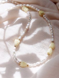 "Inspired by traditional Hawaiian leis gifted as tokens of hospitality, this handmade gold and pearl necklace features a glistening collection of pearls, gold beads and pikake flower blossoms. ✦ DETAILS ✦ ✧ Name: Mele (MEH-leh) - Song. ✧ Adjustable Length from: 16\"-18\". ✧ White Freshwater Pearls. ✧ Carved Resin Pikake Beads ✧ 14kt Gold Filled Components, Extender, and Clasp. ✧ All Ke Aloha Jewelry pieces come packaged thoughtfully, beautifully, and ready for gift giving. ✦ MORE GOLD NECKLACES Handmade Yellow Pearl Necklaces, Yellow Pearl Beaded Necklaces As Gift, Yellow Pearl Necklaces With Round Beads, Yellow Beaded Pearl Necklace, Yellow Gold Beaded Pearl Necklace For Wedding, Wedding Yellow Gold Beaded Pearl Necklace, Handmade Yellow Pearl Necklace For Gift, Traditional Cream Necklace As A Gift, Traditional Cream Necklace For Gift