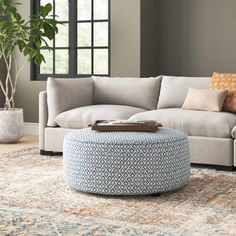 a living room with a couch, ottoman and coffee table