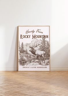 a vintage rocky mountain poster hangs on the wall in an empty room with hard wood flooring