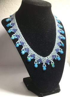 A handmade glass beaded necklace that is perfect for any occasion: parties, holidays, birthdays, anniversaries. All products are hand-crafted by my mother. Dimensions: - Actual Length: 22.5 cm - Collar Length: 13.0 cm - Width: 14.0 cm - Height: 2.0 cm Lightweight, high quality with a beaded hook as a clasp. Will respond to concerns and suggestions promptly. Acrylic Crystals: 1.2 cm. Shipping costs: Free Domestic Shipping. All orders are sent by air-mail with tracking number. Time of delivery: Es Handmade White Glass Beaded Necklaces, Handmade Blue Beaded Necklaces With Oval Beads, Handmade Blue Beaded Necklace With Oval Beads, Glass Beaded Jewelry For Crafting, Handmade White Czech Glass Necklaces, Handmade White Czech Glass Necklace, Handmade Teardrop Beaded Necklace, Unique Handmade Teardrop Beaded Necklaces, Unique Handmade Teardrop Beaded Necklace