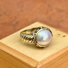 New, but old pieces, never worn, recently acquired from a premier jeweler located in Minneapolis, MN for many years- A rare opportunity! 14KT yellow gold genuine, bezel-set, Mabe pearl ring with Etruscan/ filigree design. Size 6.25 Sizable by us for a fee or your local jeweler Weight: 7.90 grams Band width: 4mm 11mm pearl Stamped 14k Formal Fine Jewelry Ring With Cabochon, Formal Fine Jewelry Cabochon Ring, Elegant White Gold Rings With Cabochon, Elegant White Gold Cabochon Rings, Elegant White Domed Rings, Classic Gold Pearl Ring With Polished Finish, Classic Moonstone Cabochon Ring For Anniversary, Yellow Gold Round Cabochon Jewelry, Yellow Gold Cabochon Jewelry