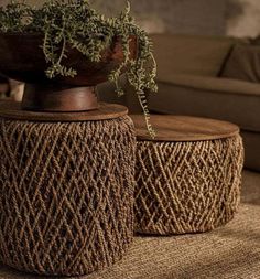 two woven stools sitting on top of a rug next to a couch and coffee table