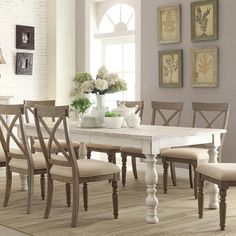 a dining room table with six chairs and a vase on the table in front of it