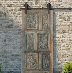 an old wooden door sitting next to a brick wall in front of a planter