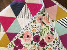 a colorful quilt with flowers and stripes on it