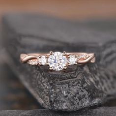 a three stone diamond ring on top of a rock