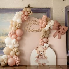 a balloon arch with a teddy bear on it