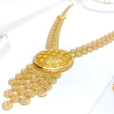 The Radiant Round Jali 5-Piece Necklace Set, crafted in exquisite 21k yellow gold weighing 69.0 grams, presents traditional craftsmanship with a modern flair. This luxurious set features a 24-inch necklace with a significant 3.75-inch drop and 2-inch adjustable links, complemented by a secure hook lock. It includes 2.1-inch earrings with hook backs, a 7.5-inch bracelet with 1-inch adjustable links, and a size 9.5 ring, all sharing the intricate Jali design. Perfect for those who appreciate detailed artistry and the opulence of gold, this set adds a majestic touch to any ensemble. PRODUCT DETAILS Gold Purity(karat): 21k Gold Weight(grams): 69.0 Item Finish: Yellow Gold Set Length: 24" Drop Length: 3.75" Adjustable Links: 2" Links Lock Style: Hook Lock Matching Earrings: Included Earring Len Luxury Long Gold Sets, Luxury Yellow Gold Round Temple Necklace, Luxury Hallmarked 22k Gold Necklaces, Luxury Yellow Gold Jewelry For Diwali, Luxury 22k Gold Hand-set Necklace, Gold Long Necklace Set, Jali Design, Long Necklace Set, Lock It