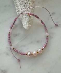 Pretty pink freshwater pearls, Japanese seed beads, metallic beads, gold seed beads pink crystals on a waxed thread, adjustable to fit most sizes. Pink Hand-strung Heishi Beads Friendship Bracelets, Adjustable Pink Heishi Beads, Adjustable Pink Gold Bracelets With Round Beads, Adjustable Pink Gold Bracelet With Round Beads, Pink Pearl Bracelet With Tiny Round Beads, Adjustable Beaded Pearl Bracelet With Round Beads, Pink Pearl Jewelry With Tiny Beads, Adjustable Pink Beaded Friendship Bracelets, Adjustable Pink Pearl Bracelet Gift