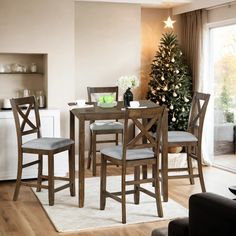 a dining room table and chairs with a christmas tree in the corner next to it