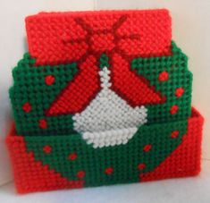 a red and green christmas ornament sitting on top of a white table