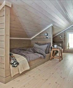 an attic bedroom with wooden walls and flooring