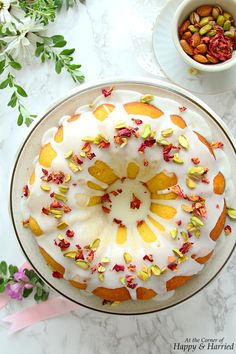 a cake with white frosting and sprinkles sitting on top of a plate