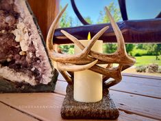 an antler's head candle holder next to a rock and amethorate