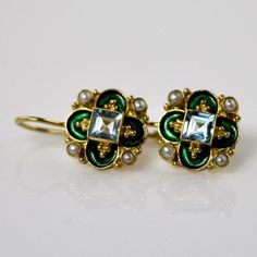 This unique Arts & Crafts Movement design showcases an onyx, iolite, blue topaz, emerald, or garnet set in a cloverleaf of emerald-green or royal blue enamel work, accented with cultured pearl. 24k gold over sterling silver. European back for pierced ears. Size: 3/4 inch. Movement Design, Big Jewelry, Historical Jewellery, Sparkly Things, Laurel Burch, Garnet Earrings, Hand Made Jewelry, Ear Jewelry, Conflict Free Diamonds