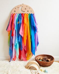 there is a rainbow colored curtain hanging on the wall next to a basket with cookies