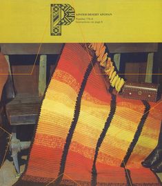 an orange and yellow afghan sitting on top of a wooden bench