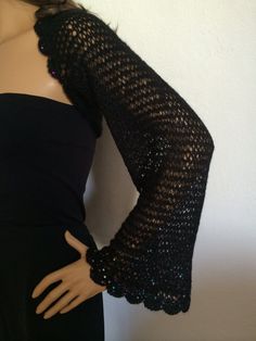 a mannequin is wearing a black dress with an open - knit shrugr