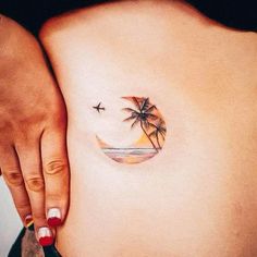 a woman's stomach with a palm tree tattoo on it