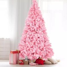 a pink christmas tree with presents under it