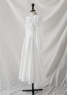 a white dress on a mannequin stand