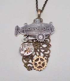 "Awesome steampunk necklace made of airship charm, watch movement and brass gears mounted on Victorian filigree . The size is 2\" by 2 1/2\" and it has 24\" antique brass chain. All my jewelry come in a nice gift box. More steampunk necklaces in my shop www.etsy.com/shop/slotzkin" Steampunk Brass Necklaces For Gifts, Steampunk Metal Locket Necklace, Steampunk Necklace With Vintage Charm For Gift, Steampunk Jewelry With Vintage Charm, Steampunk Antique Gold Jewelry Gift, Antique Gold Steampunk Jewelry Gift, Antique Gold Steampunk Jewelry As Gift, Antique Gold Steampunk Jewelry For Gift, Steampunk Metal Jewelry With Antique Finish