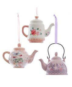 three teapots with flowers and butterflies on them are hanging from strings in front of a white background