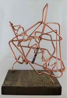 a metal sculpture on top of a wooden block