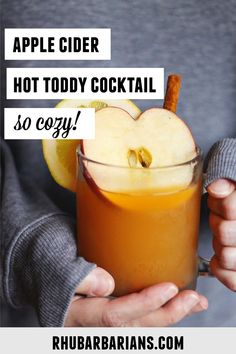 someone holding an apple cider in their hand with text overlay that reads, apple cider hot toddy cocktail so cozy